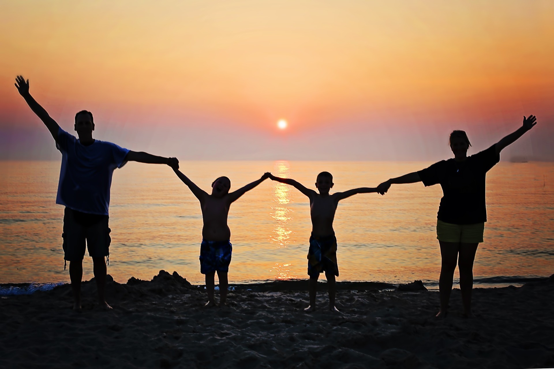 Foto: Familie händehaltend im Sonnenuntergang