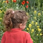 Foto: Kinderoberkörper vor Blumenwiese